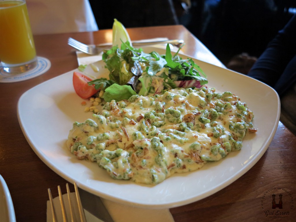 Grüne Käsespätzle mit Röstzwiebeln an kleinem Salatbouquet