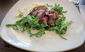 Tagliata di Manzo, gegrillte Streifen aus der Oberschale von Nebraska US Prime Beef. Angerichtet mit Knoblauch, Rosmarin, zerlassener Butter und Parmesan auf Rucola-Salat.