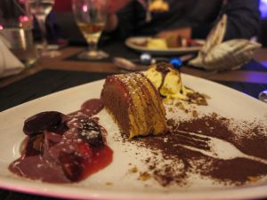 Cafe Schokoladenmousse im Baumkuchen, serviert mit Erdbeeren/Pflaumen und geeister Pecan-Nuss (8 Euro)